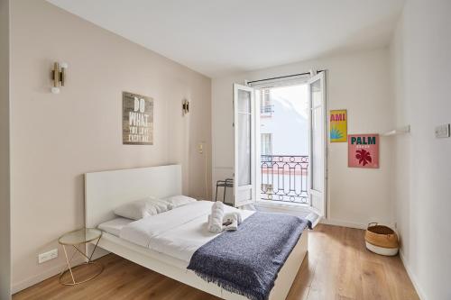 een witte slaapkamer met een bed en een raam bij Apartment Parc des expositions by Studio prestige in Parijs