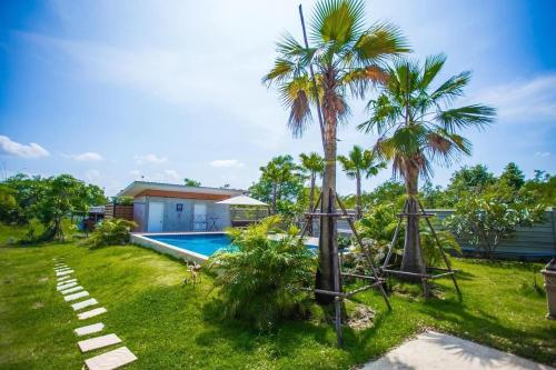 a backyard with a swimming pool and palm trees at Me and Tree Villa in Kaeng Khoi