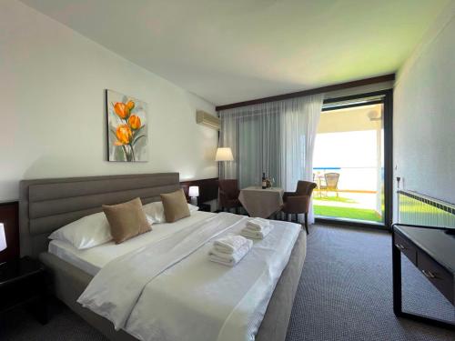 een hotelkamer met een groot bed met handdoeken erop bij CORPUS A - Hotel Albatros in Ulcinj