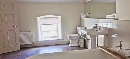 uma casa de banho com uma banheira, um WC e um lavatório. em 2 Bed Courtyard Apartment at Rockfield House Kells in Meath - Short Term Let em Kells