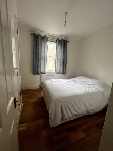 1-Bed Flat in Historic Camden في لندن: غرفة نوم بسرير ابيض ونافذة