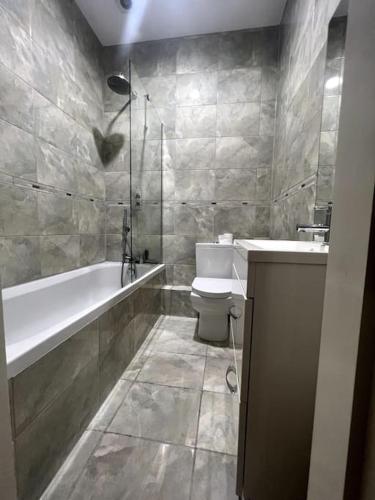 een badkamer met een bad, een toilet en een wastafel bij 1-Bed Flat in Historic Camden in Londen