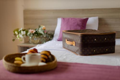 a tray of food and a suitcase on a bed at Daisi Sunset Hotel in Batumi