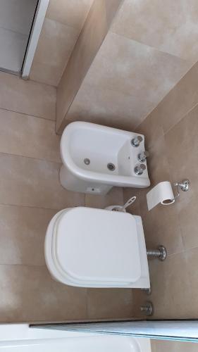 a bathroom with a white toilet and a sink at Sortie - Rio in Rosario