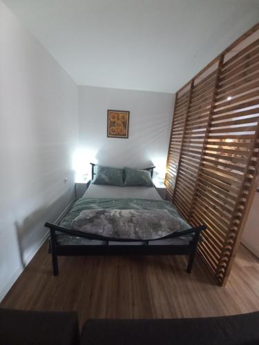 um quarto com uma cama e uma cabeceira em madeira em Dvorska oaza em Sremski Karlovci