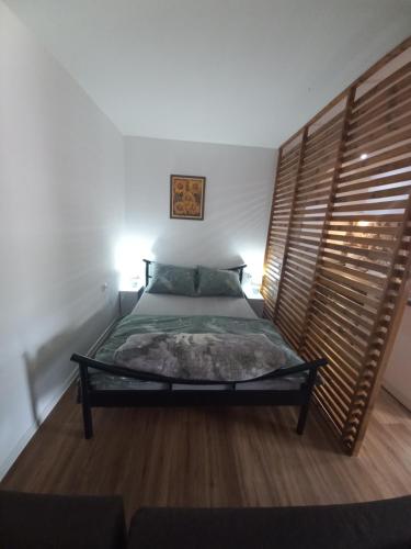 1 dormitorio con 1 cama con cabecero de madera en Dvorska oaza, en Sremski Karlovci