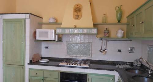 a kitchen with green cabinets and a counter top at Cà Delmo in Massa