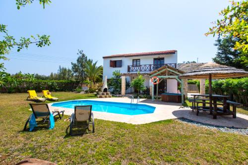 a villa with a swimming pool in front of a house at Villa Pomos Med. in Pomos