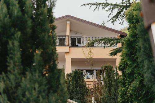 una casa con balcón y árboles frente a ella en Villa Pandora en Ohrid