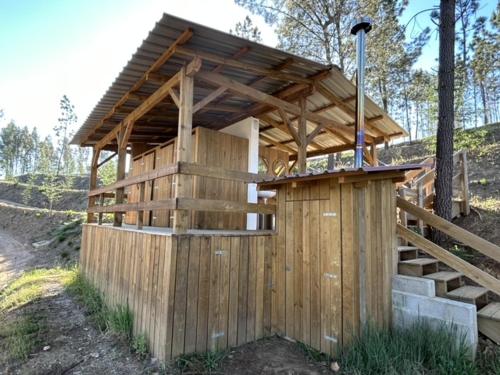 a wooden building with a porch and stairs at Quinta de São José dos Montes in Ferreira do Zêzere