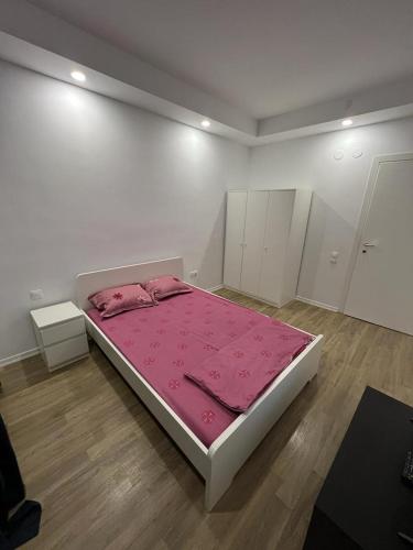 a white room with a bed with a pink blanket at Cosmopolis Single Bedroom Apartment 204 in Creţuleasca