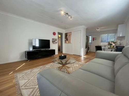 a living room with a couch and a table at Vestey Apartments in Wagga Wagga