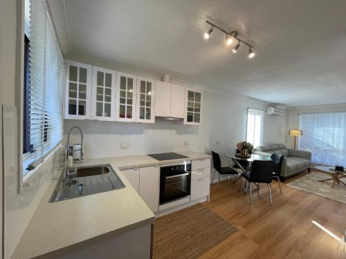 a kitchen and living room with a couch and a table at Vestey Apartments in Wagga Wagga
