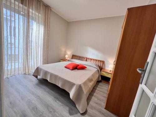 Un dormitorio con una cama con una almohada roja. en Helios, en San Giovanni Rotondo