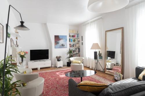 un salon blanc avec un canapé et un miroir dans l'établissement Spacious apartment on the outskirts of Paris, à Levallois-Perret