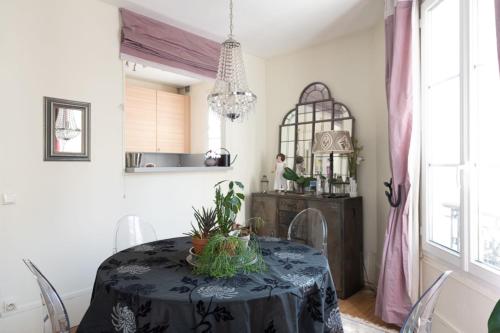une salle à manger avec une table et des chaises en noir et blanc dans l'établissement Spacious apartment on the outskirts of Paris, à Levallois-Perret