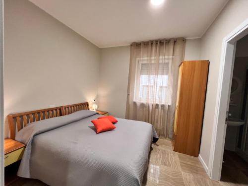 Un dormitorio con una cama con una almohada roja. en Helios, en San Giovanni Rotondo