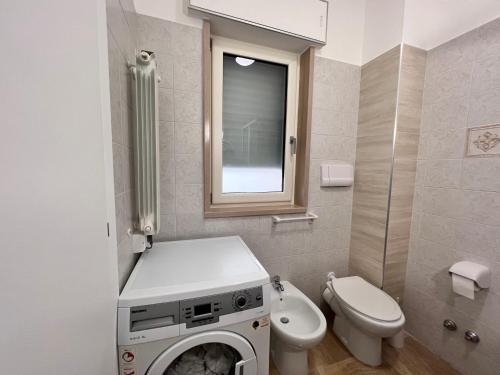 uma casa de banho com uma máquina de lavar roupa e um WC em Helios em San Giovanni Rotondo