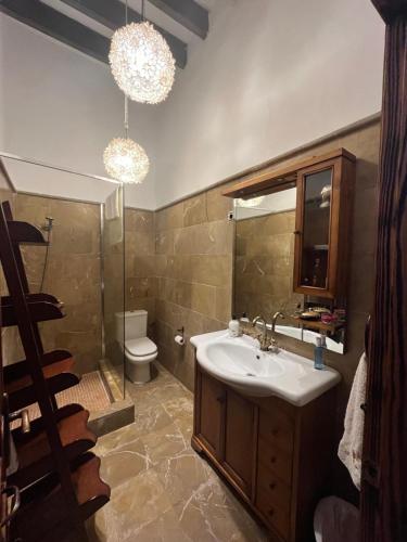 ein Badezimmer mit einem Waschbecken, einem WC und Kronleuchtern in der Unterkunft EL POBLET DE ATALAYAS in Alicante