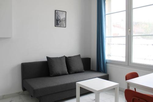 ein Wohnzimmer mit einem Sofa und einem Fenster in der Unterkunft Newly renovated cocoon with terrace near the Seine in Ivry-sur-Seine