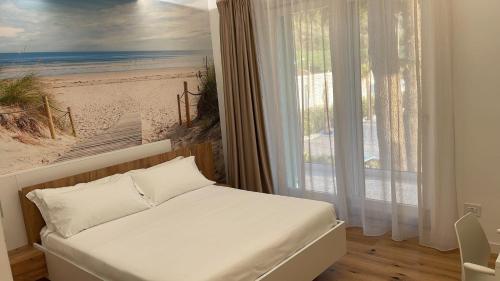 a bedroom with a bed and a painting of a beach at I-relais b&b in Montefalcone del Sannio