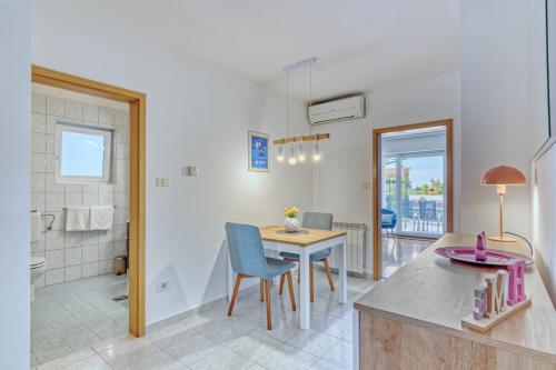 a kitchen and dining room with a table and a bathroom at Apartments Birimac in Pula