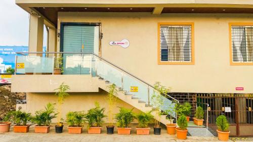 a building with stairs and potted plants in front of it at Treebo Royal Imperio, Hinjewadi in Pune