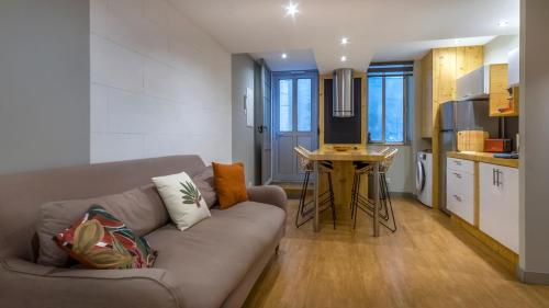 a living room with a couch and a table in a kitchen at Logement cosy au coeur du village in Peyriac-de-Mer