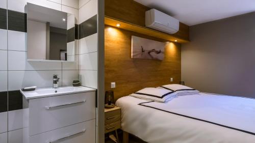 une petite chambre avec un lit et un lavabo dans l'établissement Logement cosy au coeur du village, à Peyriac-de-Mer