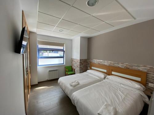 a bedroom with a bed and a television in it at El Rinconcito de dpCristal in Sarria