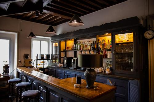 eine Bar mit einer Theke und Hockern in einem Zimmer in der Unterkunft Maison Ichigo in Voutenay-sur-Cure