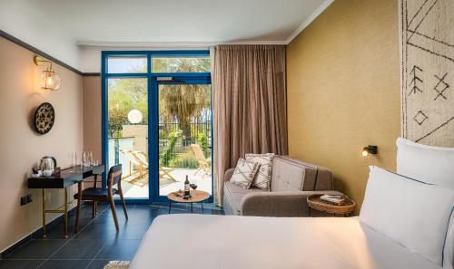 Habitación de hotel con cama y sala de estar. en Brown Red Sea - Central Park, en Eilat