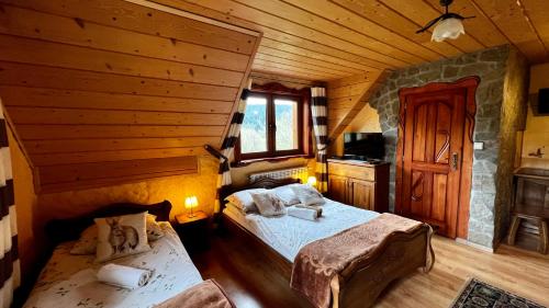 a bedroom with two beds in a log cabin at POD ROŻKAMI in Cisna