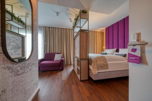 a hotel room with a bed and a mirror at FourSide Hotel Ringsheim in Ringsheim