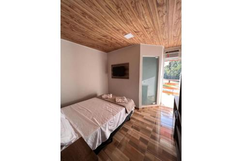 1 dormitorio con cama y techo de madera en OYO Pousada Coisa Mais Linda, en Iguape