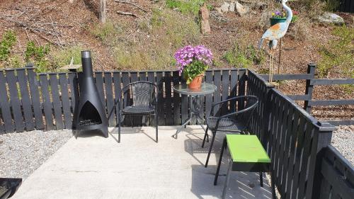 a black fence with a table and chairs and a bird at Herons Rest in Drumnadrochit