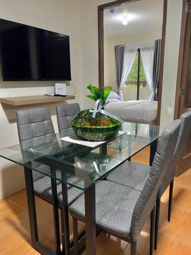 a dining room with a glass table and chairs at MQ Staycation at One Oasis in Cagayan de Oro