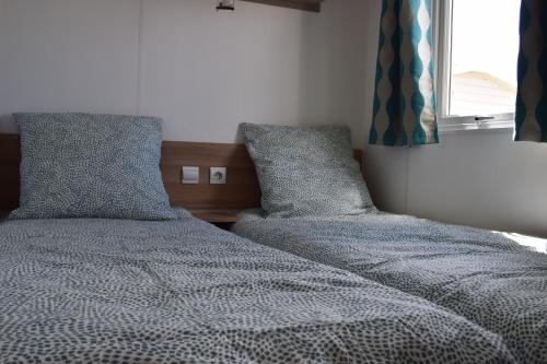 twee bedden naast elkaar in een slaapkamer bij Mobil home luxe 8 personnes avec wifi in Onzain