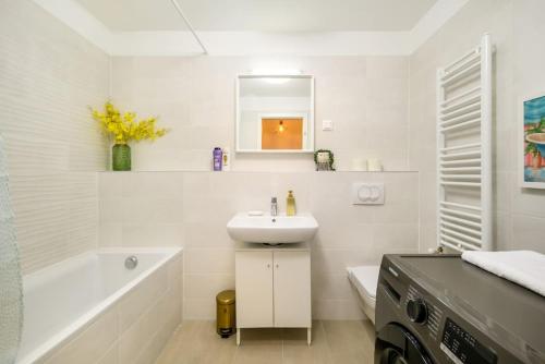 uma casa de banho branca com um lavatório e uma banheira em 5Min to Liberty Bridge-Free parking-Lovely Home. em Budapeste
