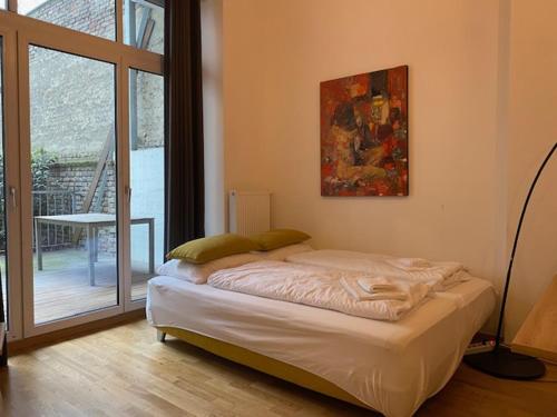 łóżko w pokoju z dużym oknem w obiekcie LOVELY HOME private TERRACE w Wiedniu
