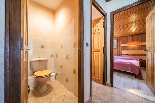a bathroom with a toilet and a bedroom at Apt Chénives 1 - Morzine in Morzine