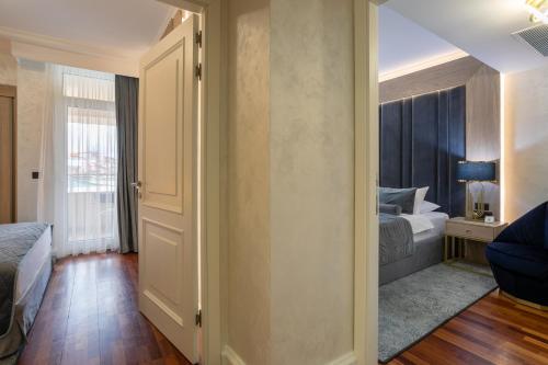 a room with a bedroom with a bed and a window at A Hoteli - Hotel Izvor in Arandjelovac