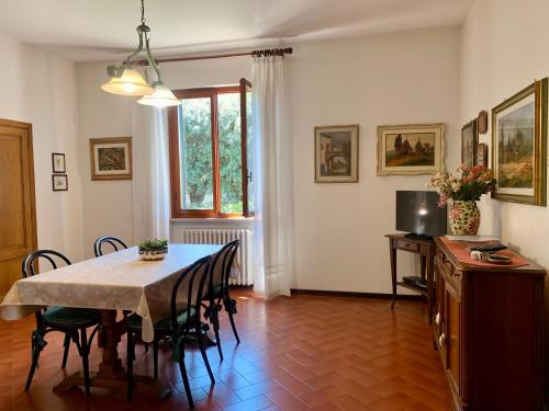 uma sala de jantar com uma mesa e cadeiras e uma televisão em Villa dei Pini em Montopoli in Val dʼArno
