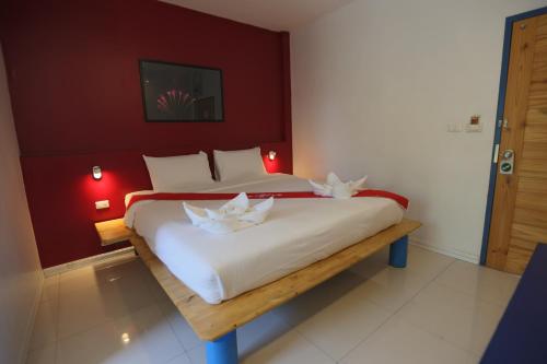 a bedroom with a large bed with two flowers on it at Hotel Montha in Chiang Mai