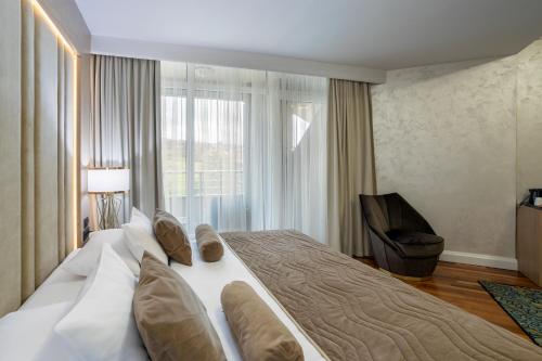 a large bed in a hotel room with a window at A Hoteli - Hotel Izvor in Arandjelovac