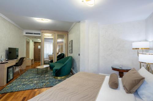 a hotel room with a bed and a living room at A Hoteli - Hotel Izvor in Arandjelovac
