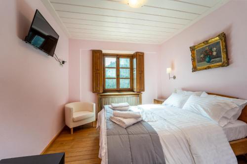a bedroom with a bed and a window at Villa Korfes-Κορφές Τριώροφη Βίλα για Οικογένειες και Παρέες in Karpenision
