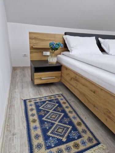 Schlafzimmer mit einem Bett mit einem Tisch und einem Teppich in der Unterkunft ORI Blue Studio Malul Muresului in Arad