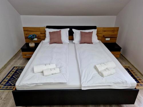 ein großes weißes Bett mit zwei Kissen darauf in der Unterkunft ORI Blue Studio Malul Muresului in Arad