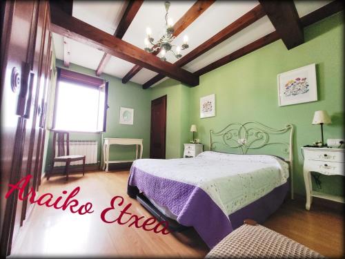 1 dormitorio con 1 cama en una habitación con paredes verdes en Araiko Etxea, 
